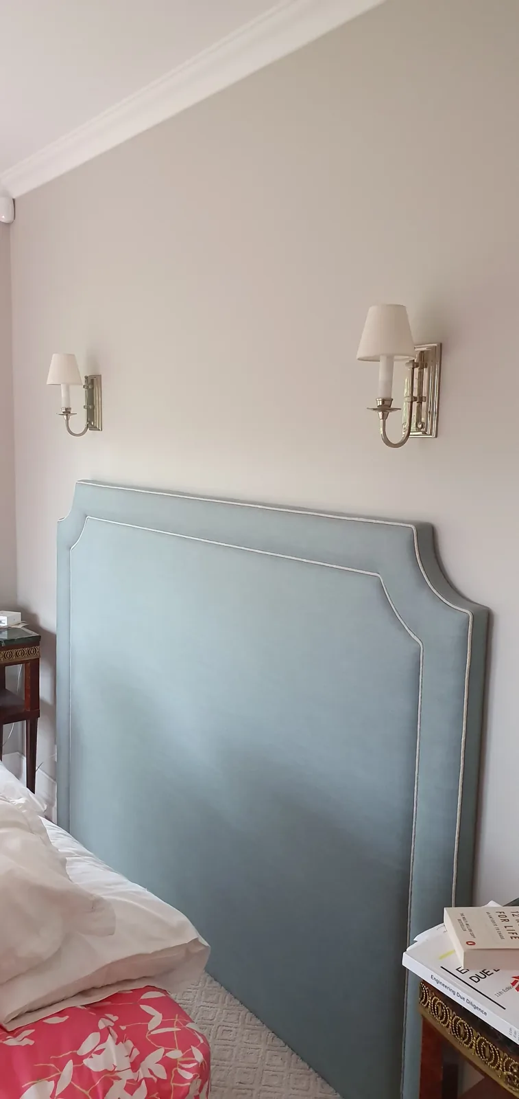 Duck egg blue upholstered bedhead in a styled bedroom