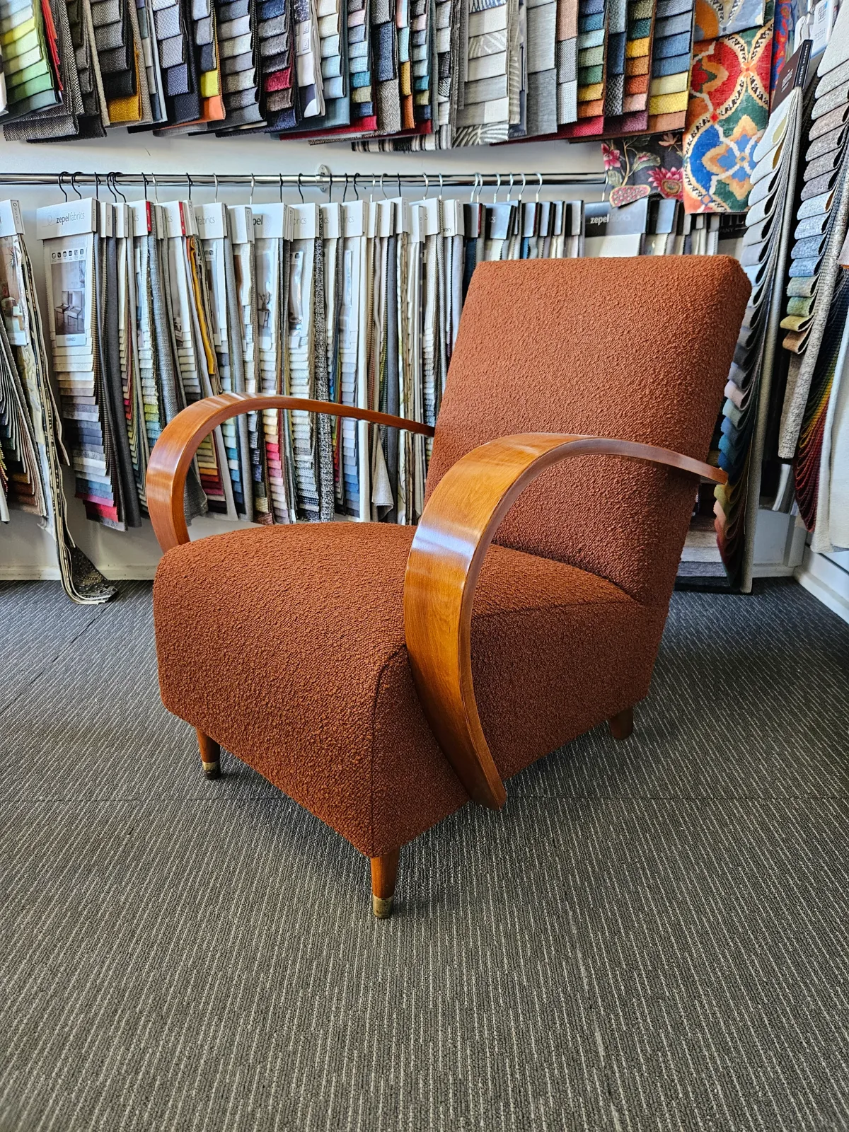 Art deco armchair reupholstered in rust boucle with polished timber arms